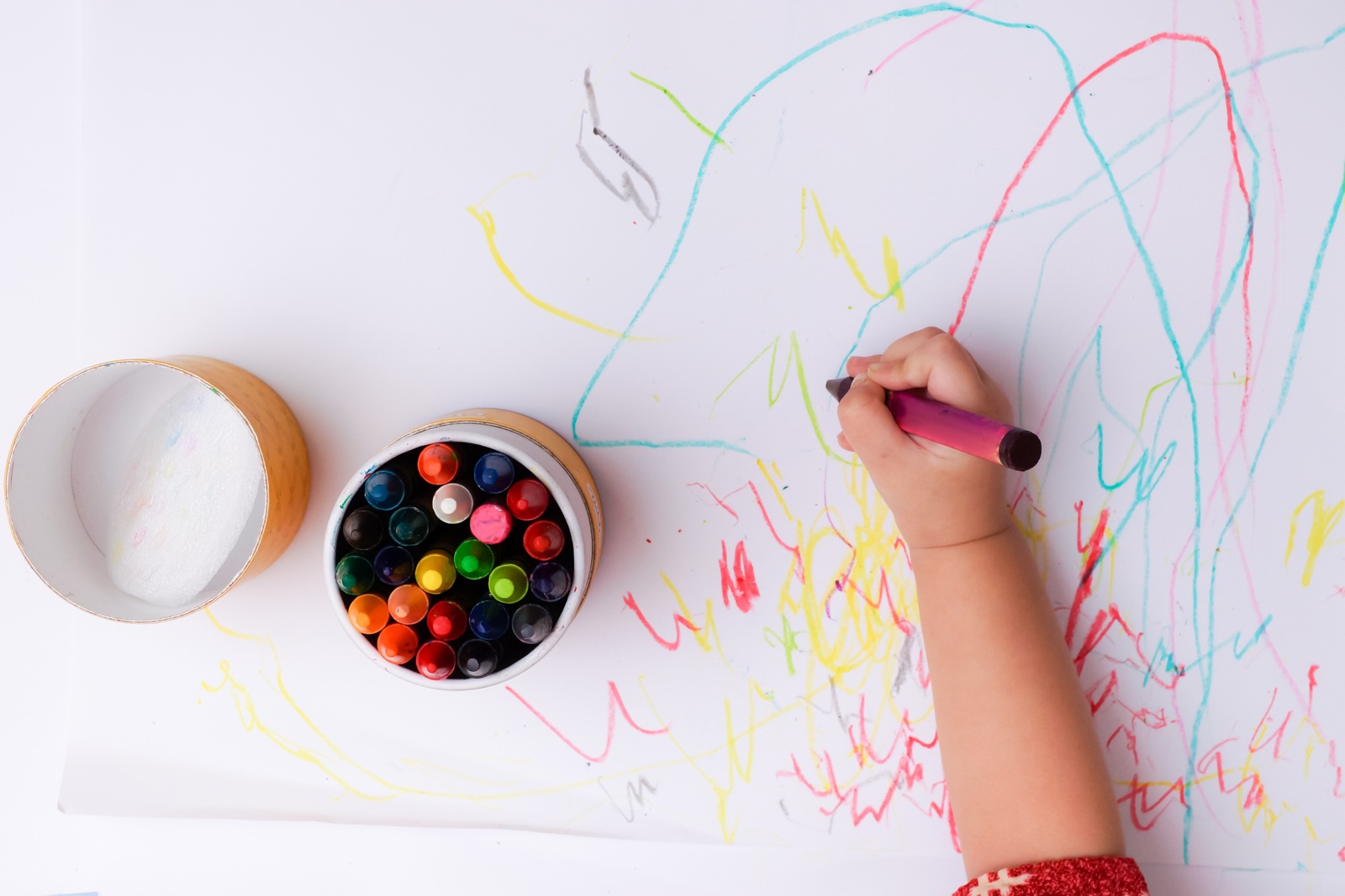 Kinderhand malt mit Buntstiften