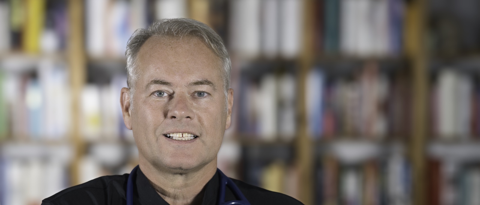 Dr. Wolfgang Stock vor einer Bücherwand